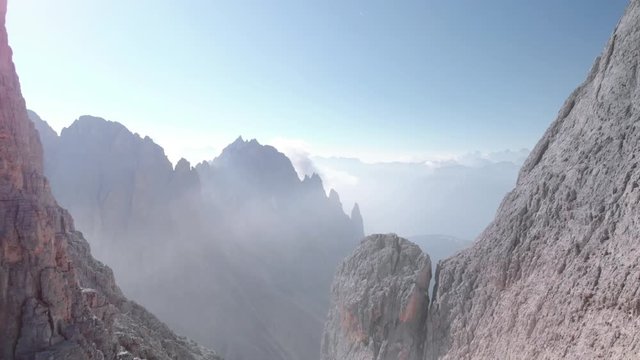 Epic Aerial Drone Shot Flying Backwards Over Man Climber Standing At Vajolet Towers Mountain In Dolomites Italy. Wanderlust Hiking Travel At Sunrise In The Alps Europe South Tyrol