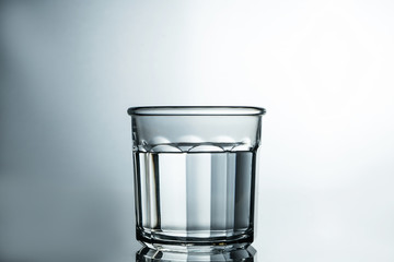 Crystal clear water. Purified water in a glass on a gray background. Pure water concept.