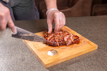 food, delicious and craft concept - Man cutting horse steak