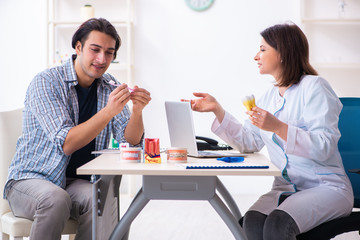 Young man visiting female doctor stomatologist