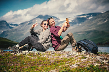 Two beautiful young girlfriends travel together in Norway, adventure, hiking, lifestyle concept - obrazy, fototapety, plakaty