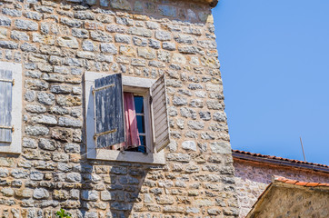 Stone wall with wooden shutters on the window