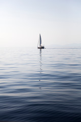 Obraz premium Sailing boat on a calm sea surface