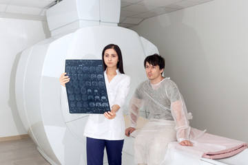 Confident pleasant female doctor working with MRI scan results and tells the patient the diagnosis. magnetic resonance imaging in a hospital