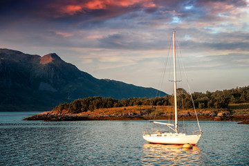 White yacht against the backdrop of mountains and sunset, Senya island. Travel to Norway