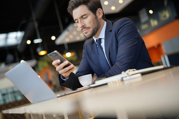Businessman connected at the airport with smartphone