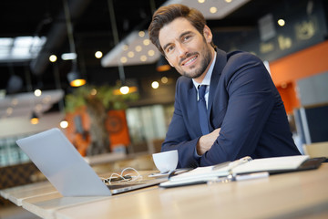 Fototapeta premium Businessman working on laptop while waiting for client