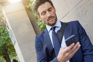 Businessman in the street using smartphone