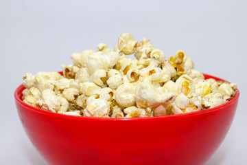 Popcorn in red with caramel on white background