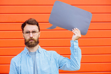 Attractive young beard man in circle glasses with sad toughtful emotion on his face holding a black...