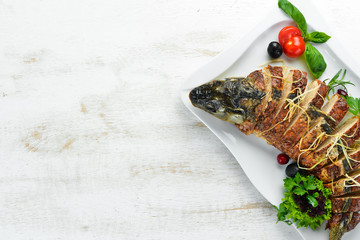 Baked stuffed fish carp with vegetables. Restaurant dishes. Top view. Free space for your text.
