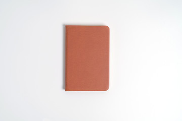 top view blank orange leather diary on white desk