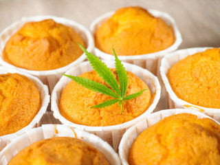 Delicious homemade baked cinnamon muffins with marijuana leaf garnish. Cookies with cannabis and buds. Treatment of medical marijuana for use in food.
