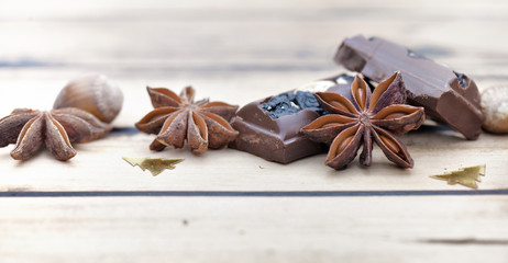 close on star anise with chocolat and  christment confetti on wooden background