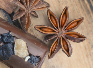 close on star anise with chocolat on brown wooden background