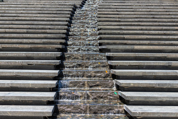 City stream. Water cascade. Steps down and in the middle, water flows down the steps. Modern designer steps.