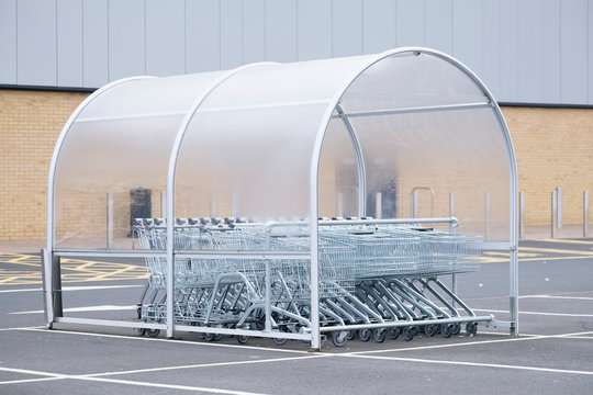 Shopping Trolley Group In Shelter At Supermarket Shop Car Park