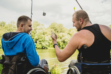 Handicapped men fishing at a lake. Wheelchair. Camping.