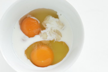 raw egg and milk in bowl for cooking image