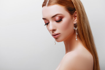 Naklejka premium Portrait of young tender redhead teenage girl with healthy freckled skin. Caucasian woman model with ginger hair posing indoors