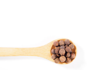 Allspice (Jamaica pepper) in the wooden spoon horizontally on white background