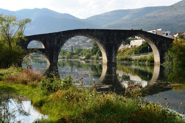 Fototapeta na wymiar old stone bridge and reflection on river