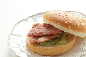 Pan fried luncheon meat and sausage in sesame bun for sandwich breakfast