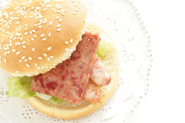 Pan fried luncheon meat and sausage in sesame bun for sandwich breakfast