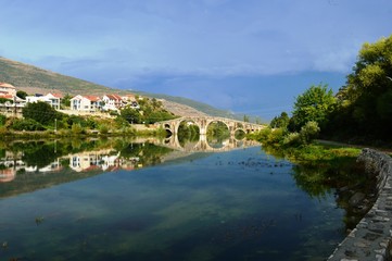 Fototapeta na wymiar reflection of a stone bridge in a river