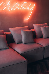 Cozy Sofa in neon light. Dark photo. 