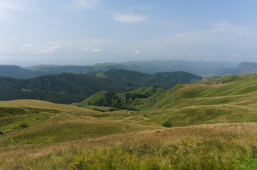 Naklejka premium Lush green lawns meadows and mountains above 2000 m on the gumbashi pass in the northern caucasus between dombay and kislowodsk, raw original picture