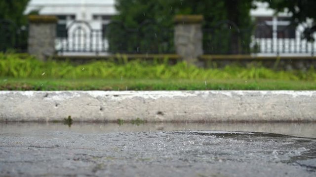 Legs of a runner in sneakers. Sports woman jogging outdoors, stepping into muddy puddle. Single runner running in rain, making splash. Slow motion