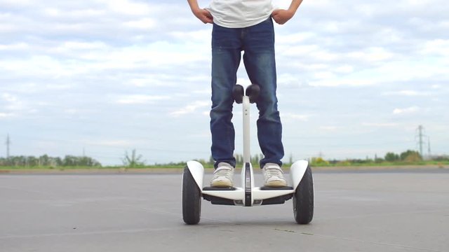 a schoolboy stands on a gyroscooter before leaving for study
