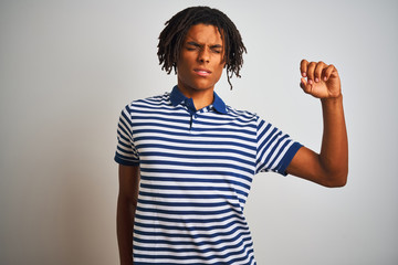 Afro man with dreadlocks wearing striped blue polo standing over isolated white background stretching back, tired and relaxed, sleepy and yawning for early morning