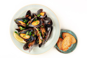 Marinara mussels, shot from the top on a white background with toasted bread and copy space