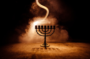 Low key image of jewish holiday Hanukkah background with menorah on dark toned foggy background - obrazy, fototapety, plakaty