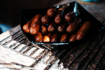 sausages with a chapel cooked on the grill in a black plate, delicious food