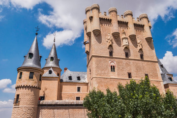 Fototapeta premium Partial view of the Castle from the entrance to the monument and drawbridge, Juan II Tower, rising out on a rocky crag, built in 1120, Segovia, Castilla y Leon, Spain