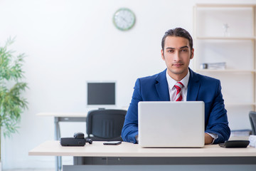Young male businessman sitting in the office