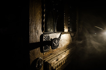 Close up view of old antique wooden door inside dark room. Selective focus