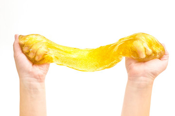 Modern toy called slime. Child playing transparent yellow slime. Hands holding a mucus isolated on...