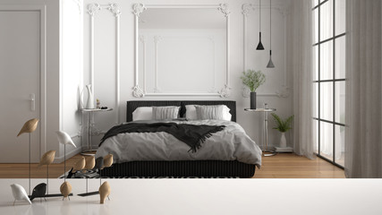 White table top or shelf with minimalistic bird ornament, birdie knick - knack over blurred classic luxury bedroom with double bed, parquet and decors, contemporary interior design