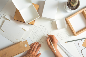 The designer develops, draws sketches for eco-packaging, cardboard boxes. 