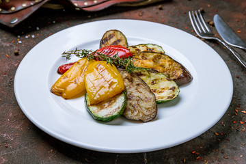 grilled vegetables on a plate on dark concrete rustic table