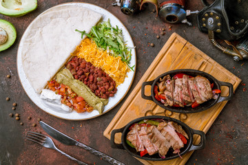 Fajitas with beef on dark concrete rustic table