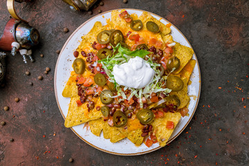 Mexican nachos chips with sauces on dark concrete rustic table