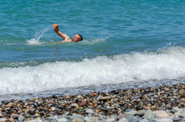 a man swims in the sea on a Sunny day; the concept of recreation, sports