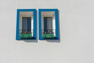 Two windows with flower pots on white wall in Bodrum, Turkey
