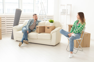 Positive smiling young girl sitting against her laughing in a new living room while moving to a new home. The concept of joy from the possibility of finding new housing.
