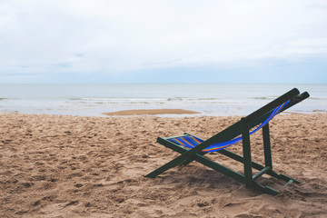 Fototapeta na wymiar A single beach chair by the sea with blue sky background